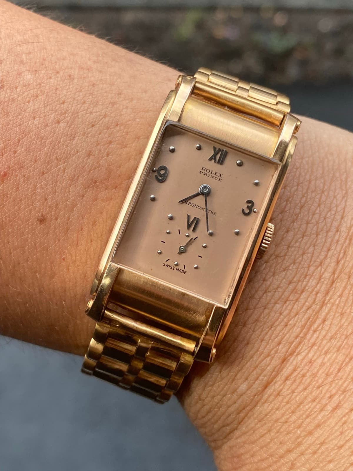 Rolex Prince Chronomètre am Handgelenk — rechteckiges Goldgehäuse mit lachsfarbenem Zifferblatt